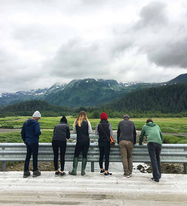 Familiary Tour participants looking over road into river in Alaska